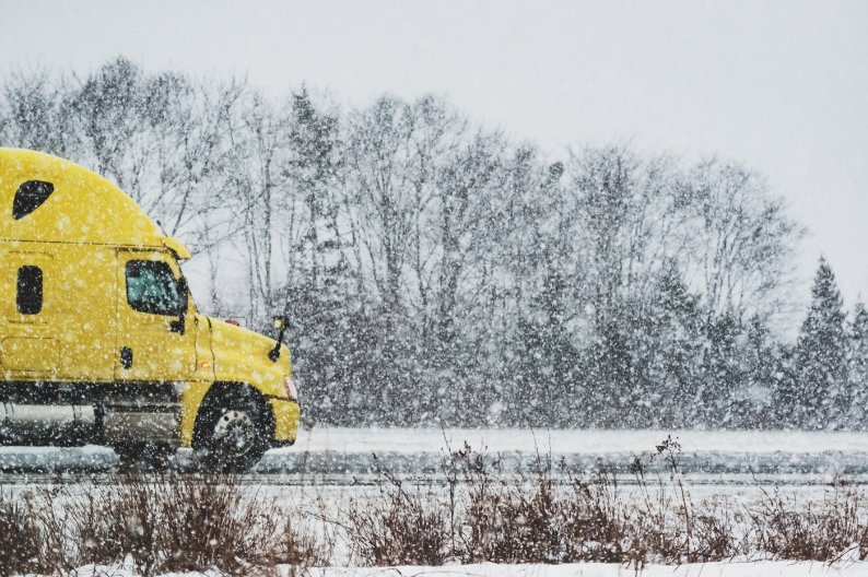 Jack knifed truck in ditch next to icy road